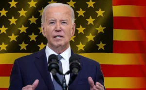 جو بايدن يخطب ومن خلفه العلم الأمريكي